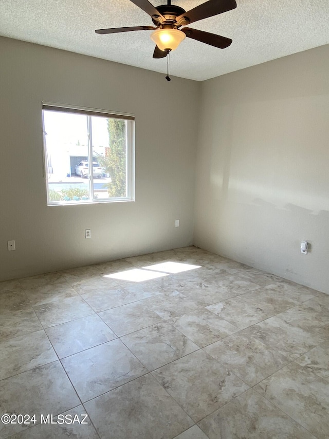 unfurnished room with a textured ceiling and ceiling fan