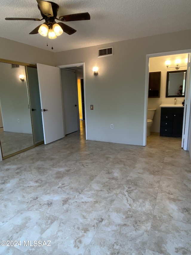 unfurnished room featuring a textured ceiling, ceiling fan, and sink