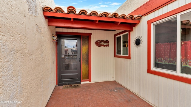 view of exterior entry with a patio area