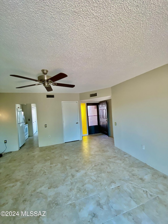 unfurnished room with a textured ceiling and ceiling fan