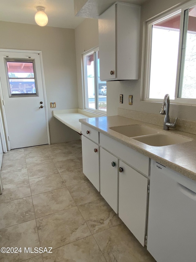 kitchen with sink, plenty of natural light, white dishwasher, and white cabinetry