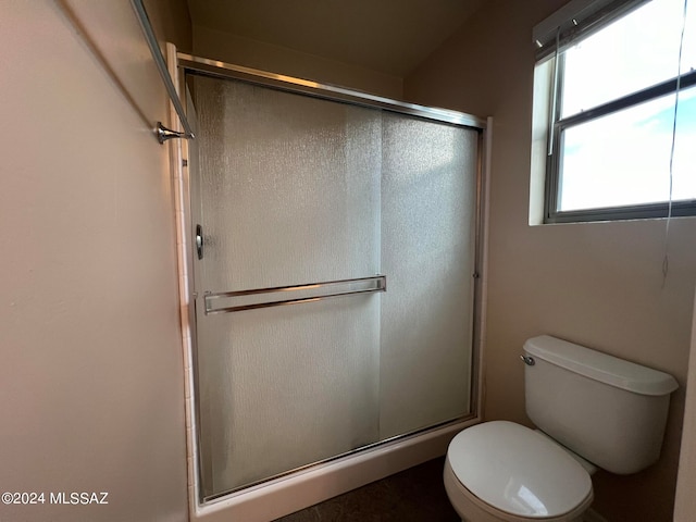 bathroom with toilet and a shower with door