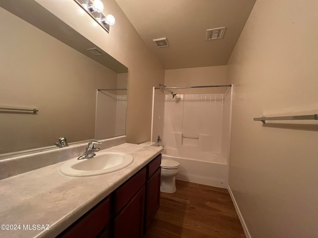 full bathroom featuring hardwood / wood-style flooring,  shower combination, vanity, and toilet