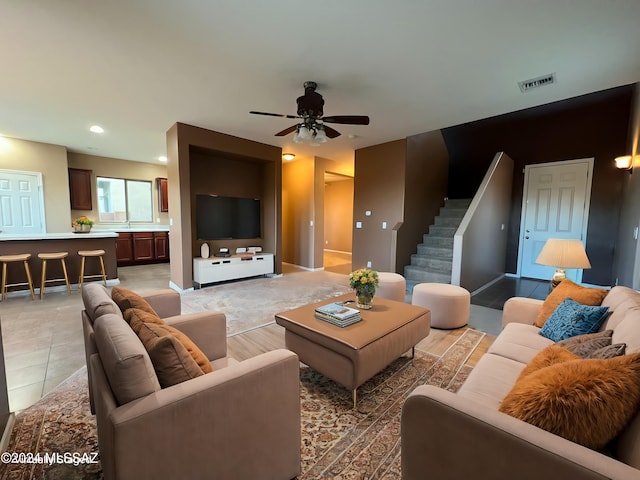 living room featuring baseboards, visible vents, recessed lighting, a ceiling fan, and stairway