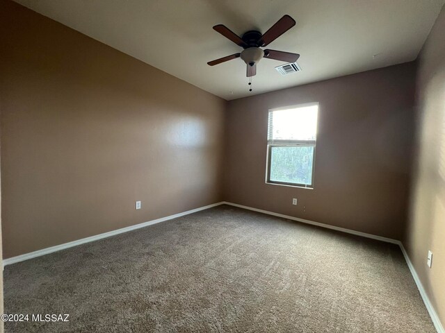 empty room with ceiling fan and carpet