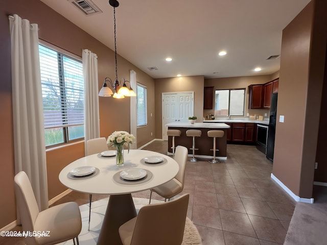 tiled dining space featuring an inviting chandelier