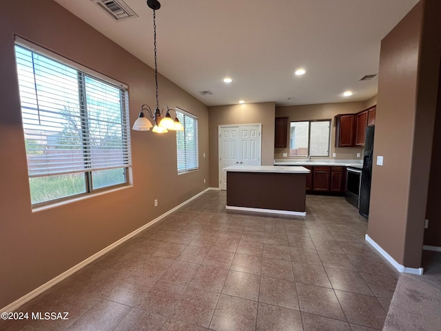 kitchen with decorative light fixtures, a chandelier, a center island, black fridge, and stainless steel electric range