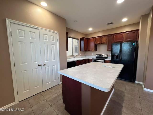 kitchen with light tile patterned floors, black appliances, sink, and a kitchen island