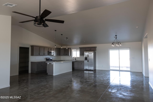 kitchen with sink, appliances with stainless steel finishes, hanging light fixtures, high vaulted ceiling, and a center island