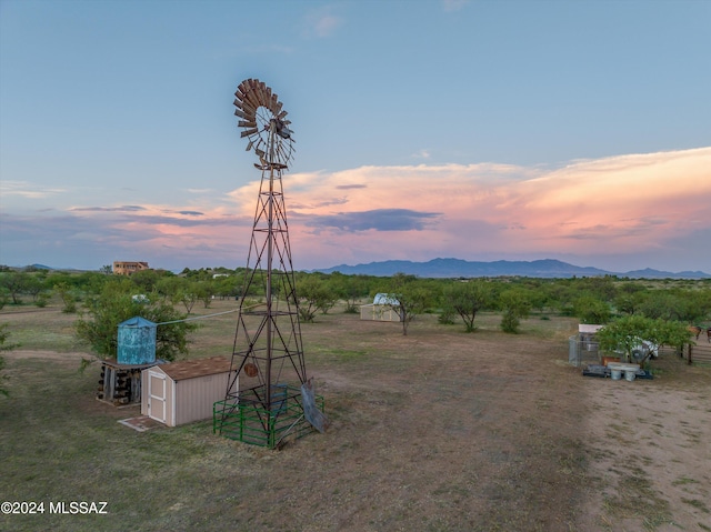 exterior space with a mountain view, a storage shed, and a rural view