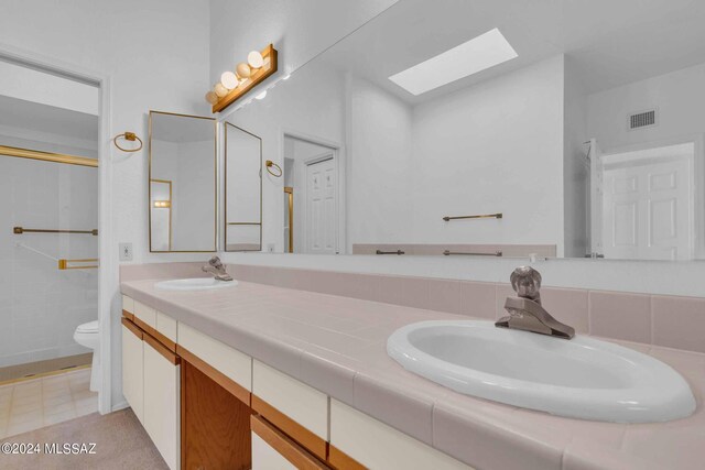 bathroom featuring tile patterned floors, a relaxing tiled tub, and toilet