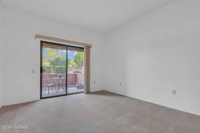 carpeted empty room featuring ceiling fan and a textured ceiling