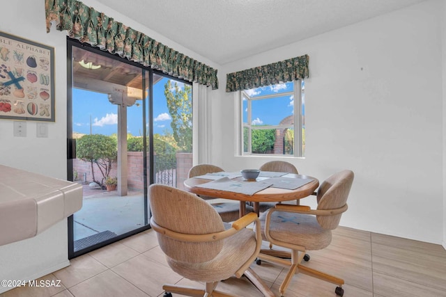 tiled dining room with a textured ceiling