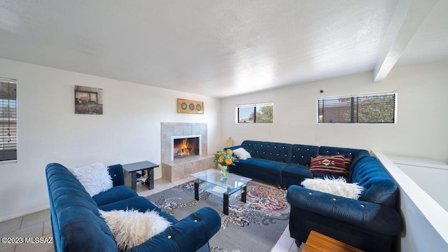 tiled living room featuring a textured ceiling, a tile fireplace, and beamed ceiling