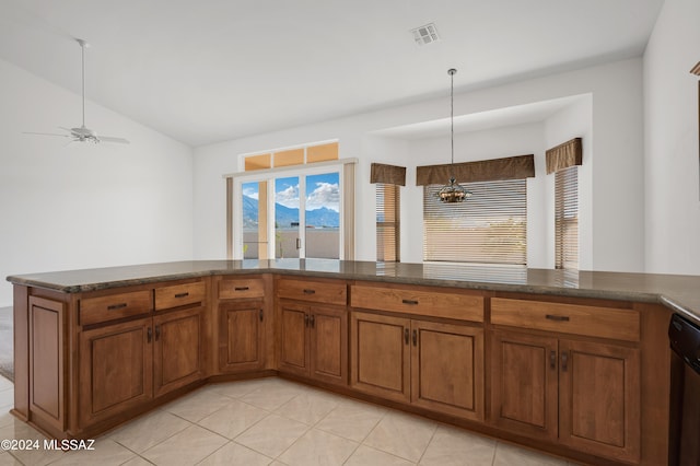 kitchen featuring pendant lighting, lofted ceiling, light tile patterned floors, kitchen peninsula, and stainless steel dishwasher