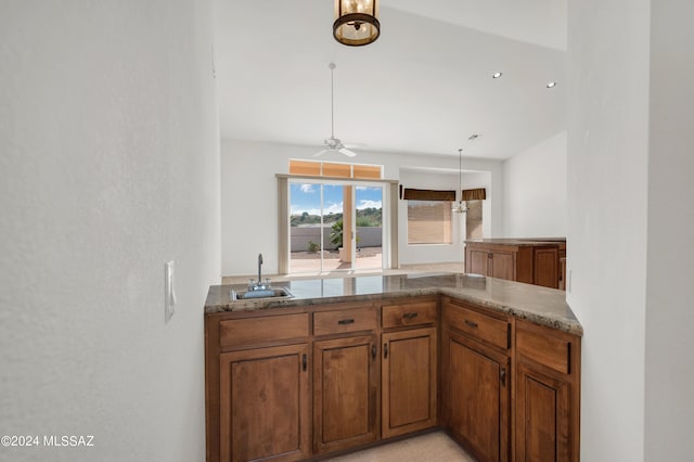 kitchen featuring ceiling fan, sink, hanging light fixtures, and kitchen peninsula