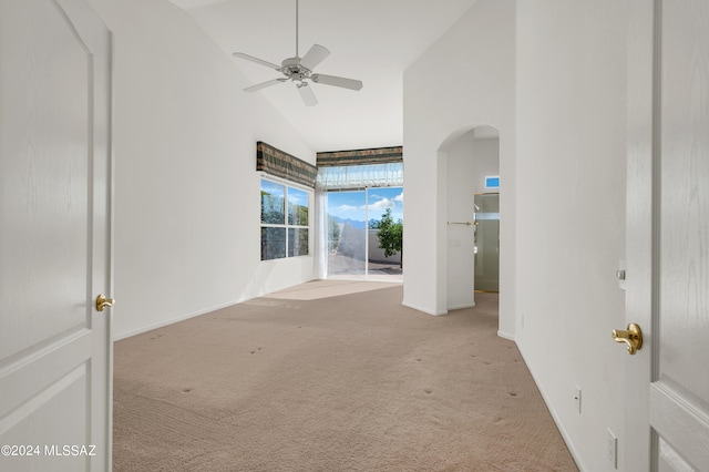 carpeted spare room featuring ceiling fan and high vaulted ceiling