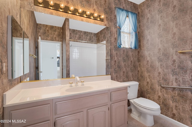 bathroom featuring a tile shower, vanity, and toilet