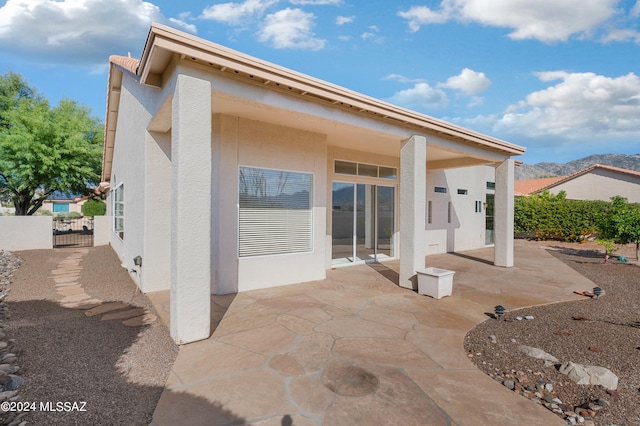 back of property with a patio area and a mountain view