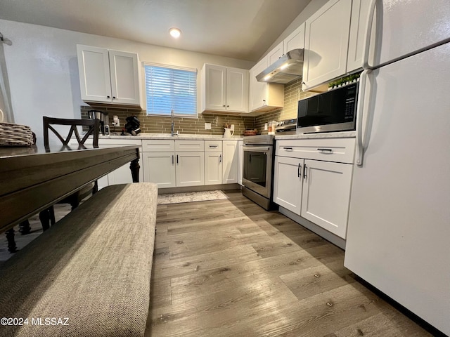 kitchen featuring white cabinetry, stainless steel appliances, decorative backsplash, hardwood / wood-style floors, and sink