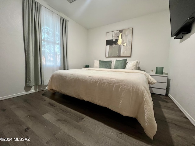 bedroom with dark wood-type flooring