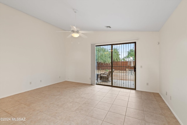 tiled empty room with vaulted ceiling and ceiling fan