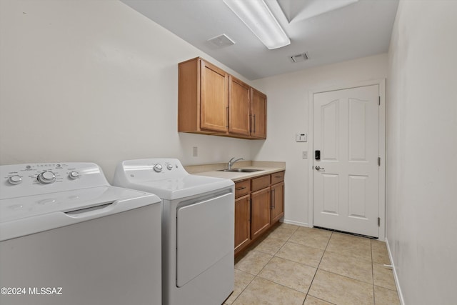 laundry area featuring cabinets, sink, light tile patterned flooring, and washing machine and clothes dryer