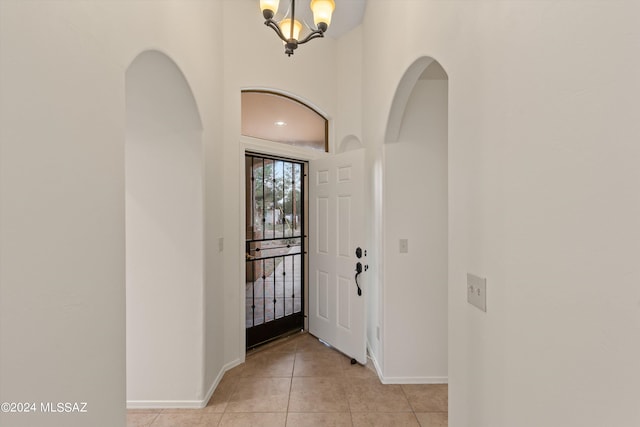 entryway featuring light tile patterned floors and an inviting chandelier