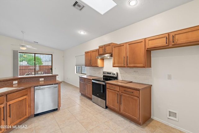 kitchen featuring ceiling fan, stainless steel appliances, decorative backsplash, lofted ceiling, and light tile patterned floors