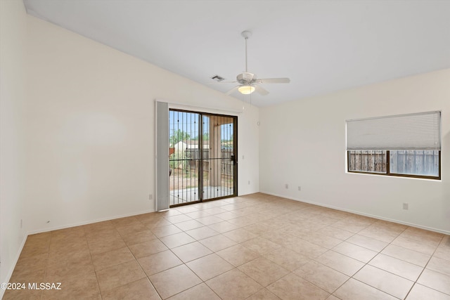 spare room with light tile patterned floors, vaulted ceiling, and ceiling fan