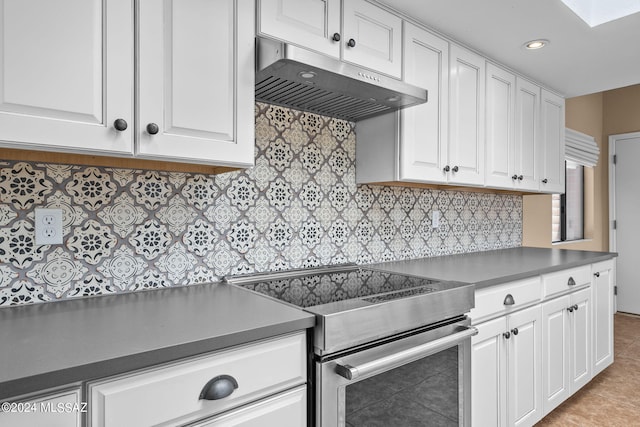 kitchen with light tile patterned flooring, white cabinets, decorative backsplash, and stainless steel electric range