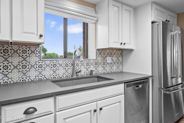 kitchen with backsplash, sink, white cabinets, and appliances with stainless steel finishes