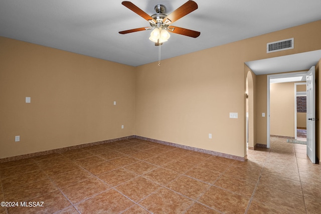 tiled spare room with ceiling fan