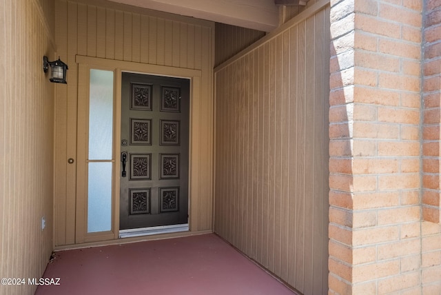 doorway to property featuring brick siding