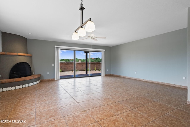 unfurnished living room with a fireplace, light tile patterned floors, and ceiling fan