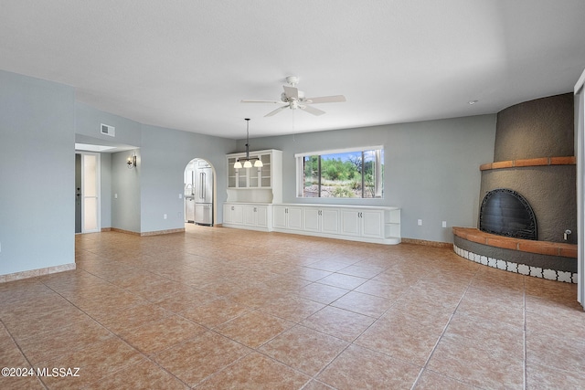 unfurnished living room with a fireplace, light tile patterned floors, and ceiling fan