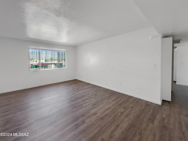 unfurnished room featuring dark wood-type flooring