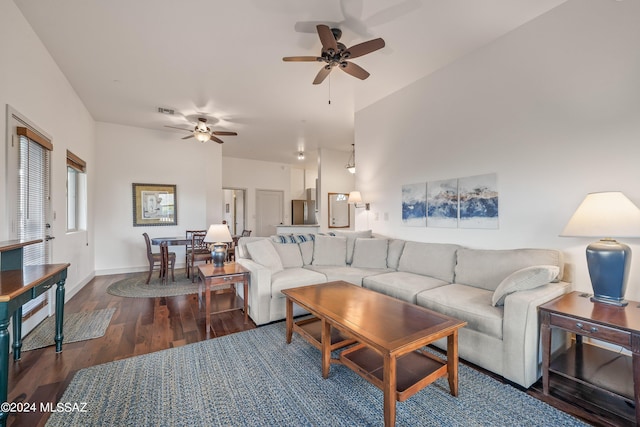 living room featuring ceiling fan and dark hardwood / wood-style flooring