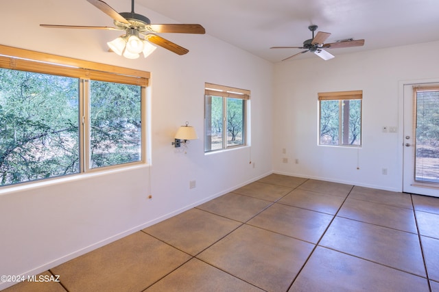 tiled empty room with ceiling fan and vaulted ceiling