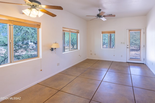 tiled spare room with ceiling fan