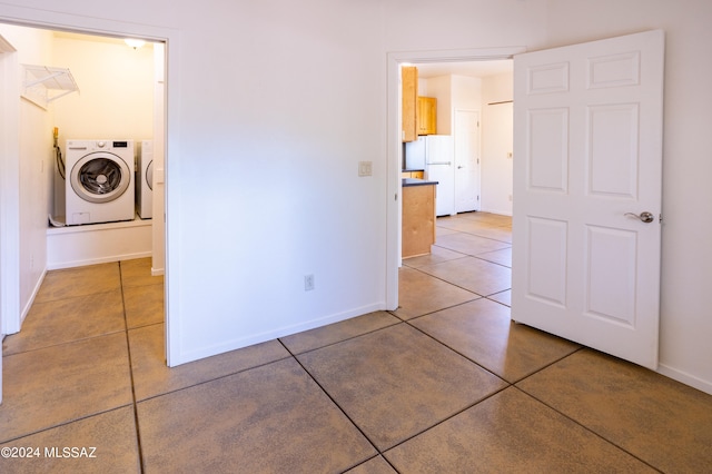 tiled empty room featuring washing machine and dryer