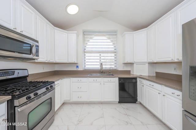 kitchen featuring stainless steel appliances, lofted ceiling, white cabinetry, and sink