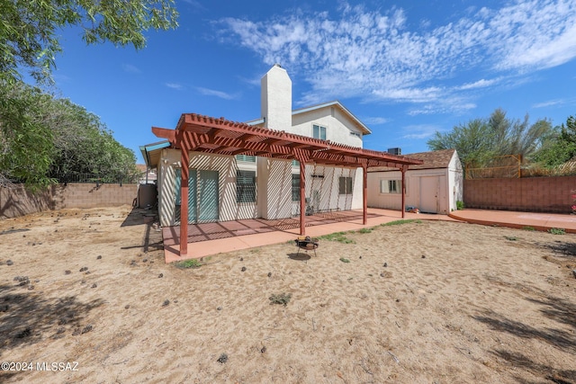 rear view of house with a pergola, a patio, and a shed