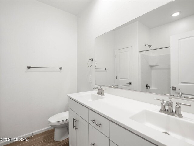 350 N Pecan Canyon Ln, Sahuarita, AZ 85629 - full bath featuring toilet, wood finished floors, double vanity, a shower, and baseboards