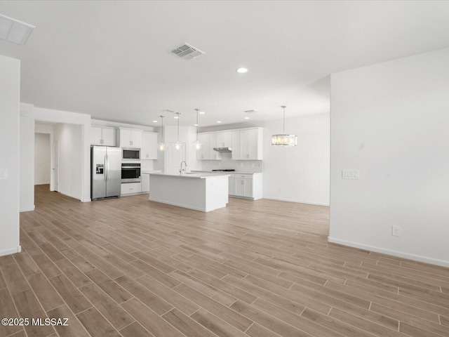 350 N Pecan Canyon Ln, Sahuarita, AZ 85629 - unfurnished living room featuring light wood finished floors, baseboards, recessed lighting, a sink, and a chandelier