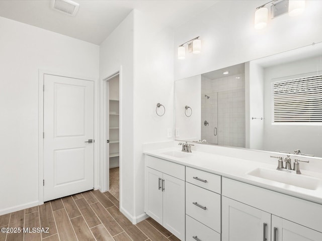 350 N Pecan Canyon Ln, Sahuarita, AZ 85629 - bathroom with a shower stall, double vanity, wood finish floors, and a spacious closet