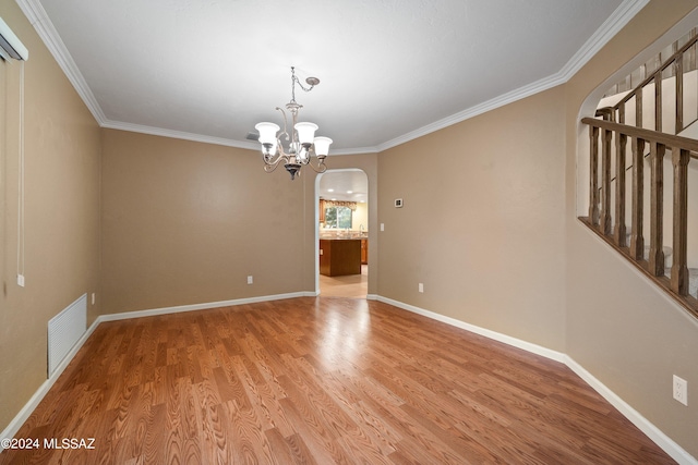 unfurnished room with hardwood / wood-style flooring, a notable chandelier, and ornamental molding