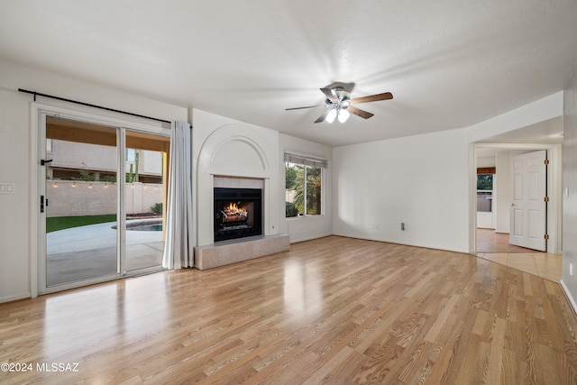 unfurnished living room with ceiling fan and light hardwood / wood-style floors