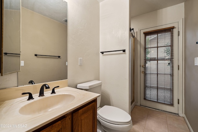 bathroom with vanity, toilet, and tile patterned floors