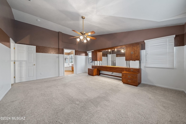 unfurnished living room with ceiling fan, lofted ceiling, and light colored carpet